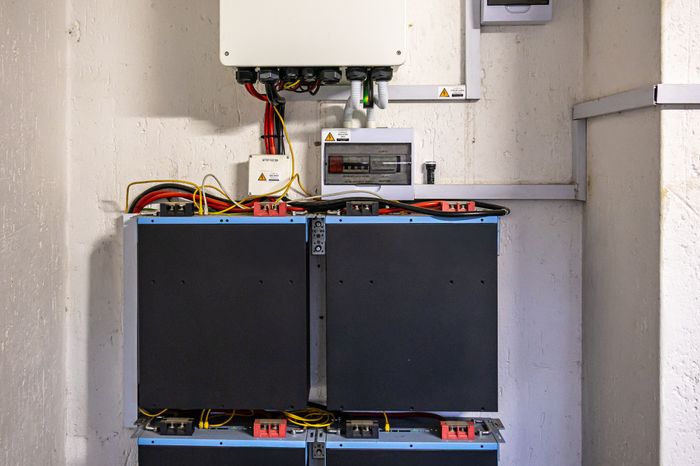 Wandmontierter Wechselrichter mit gestapelten Batteriemodulen im Hausanschlussraum